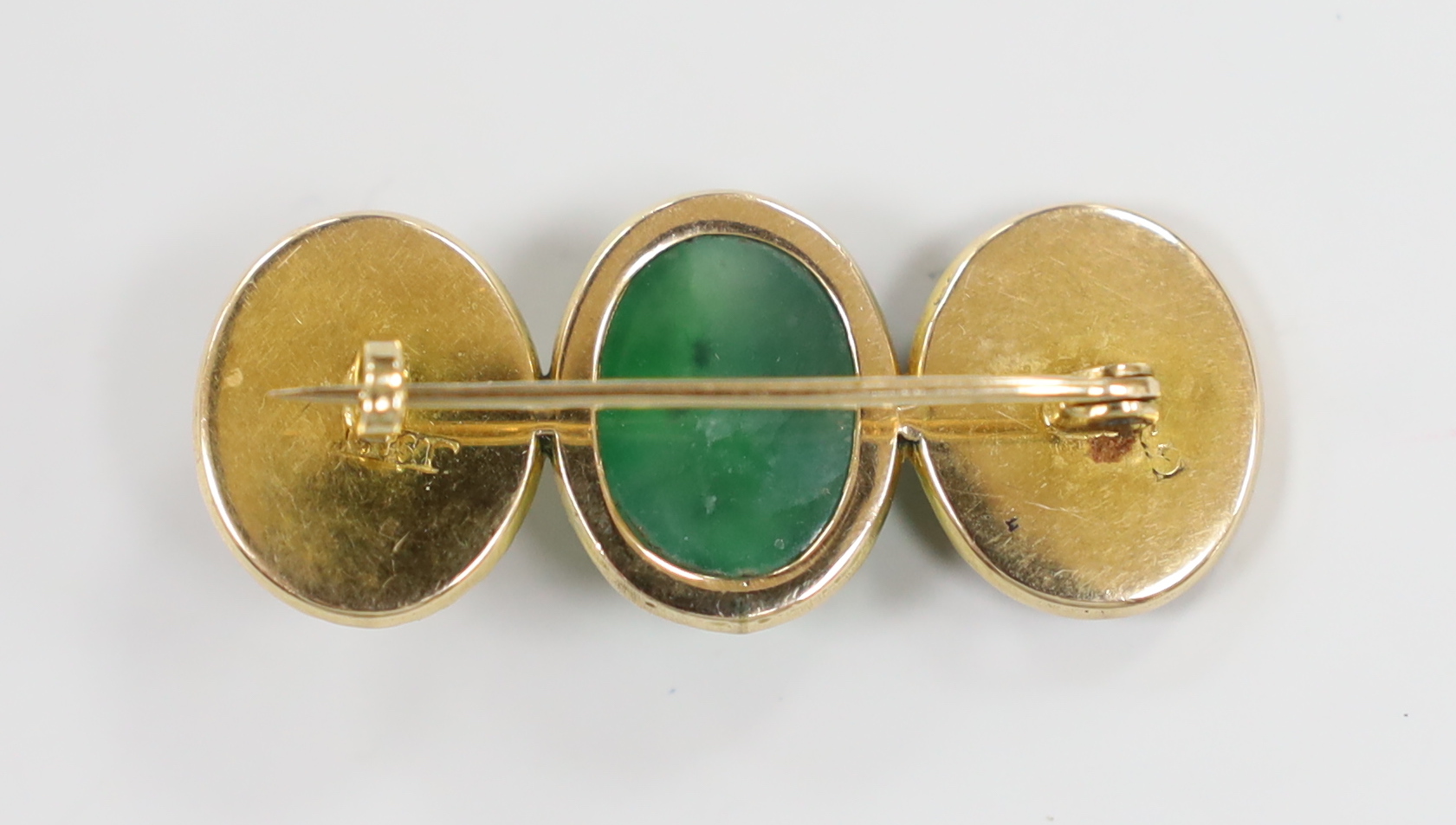 A Chinese yellow metal and cabochon jade and Chinese character set triple oval motif brooch, 39mm, gross weight 6.2 grams.